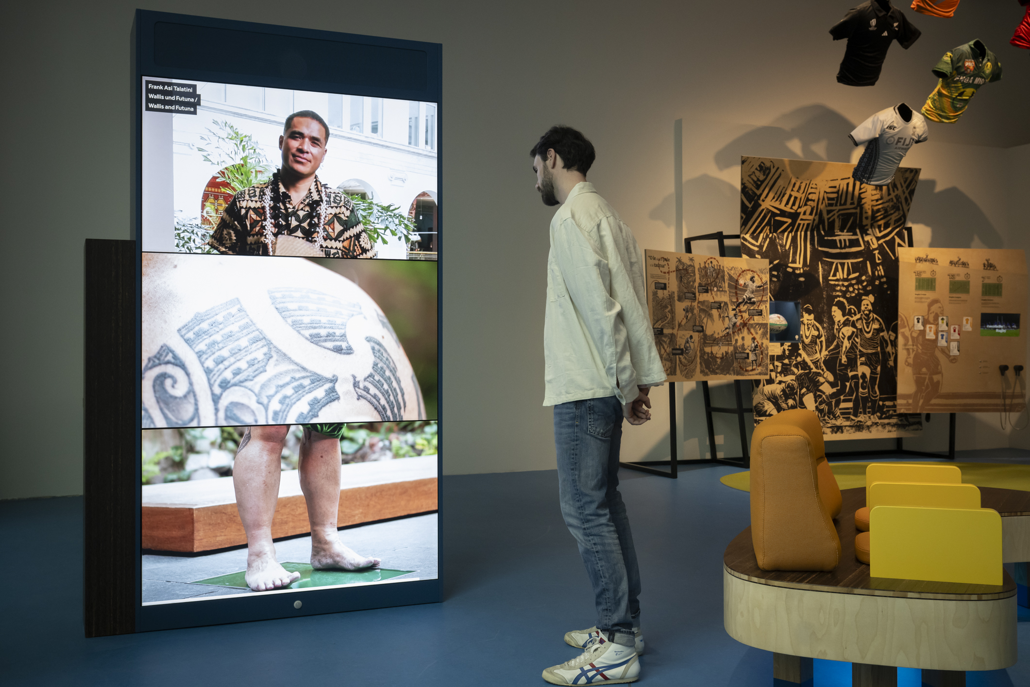 A man stands in front of a screen as part of the exhibition