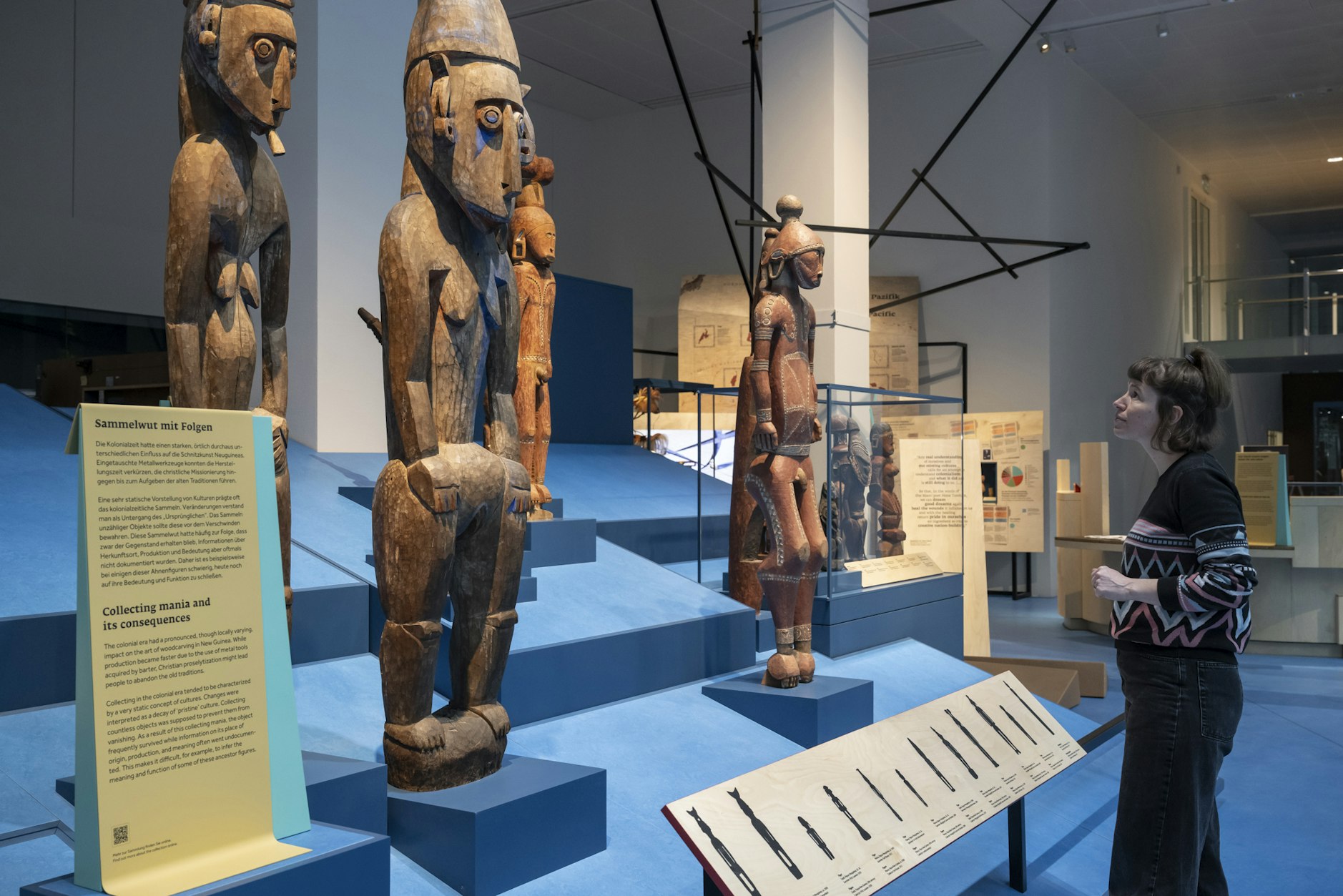 A lady looks at large statues as part of the exhibition.